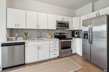 A modern kitchen with stainless steel appliances and white cabinets
